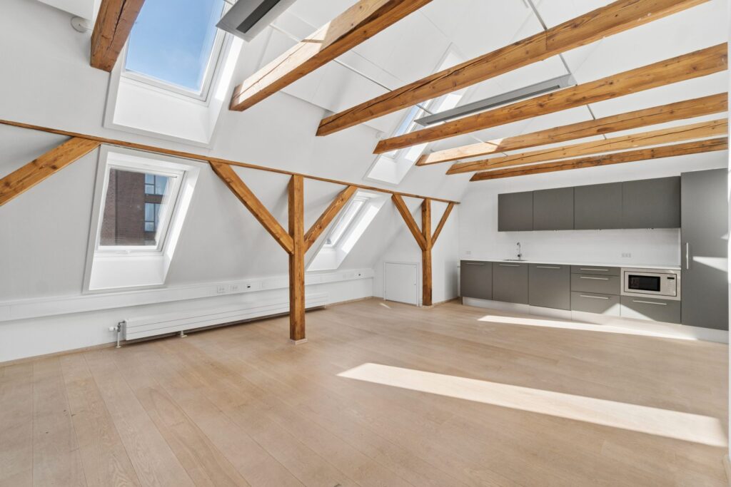 Moderne kontormiljø i Kirkebjerg Vigespor med lyse arbejdsrum og bevarede industrielle detaljer.