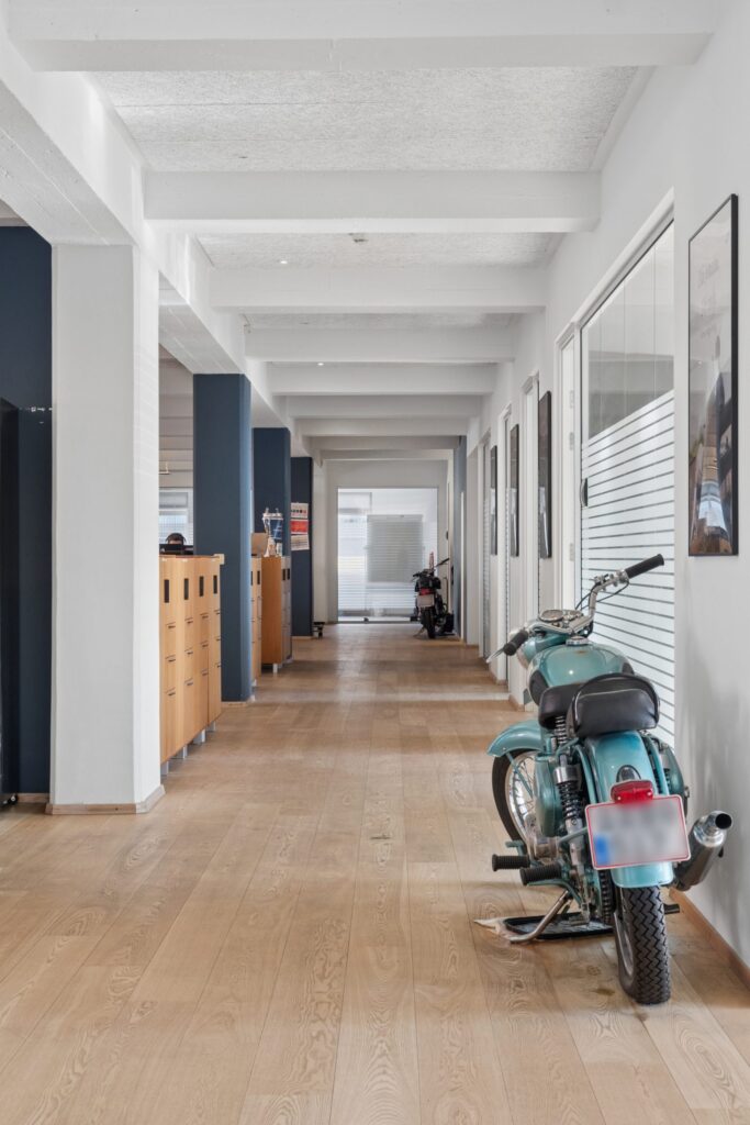 Moderne kontormiljø i Kirkebjerg Vigespor med lyse arbejdsrum og bevarede industrielle detaljer.