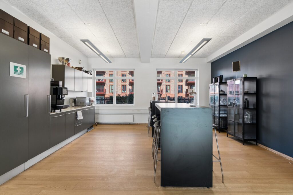 Moderne kontormiljø i Kirkebjerg Vigespor med lyse arbejdsrum og bevarede industrielle detaljer.