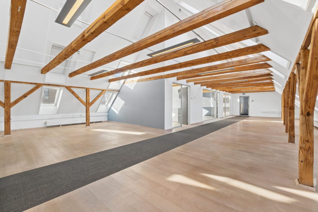 Moderne kontormiljø i Kirkebjerg Vigespor med lyse arbejdsrum og bevarede industrielle detaljer.