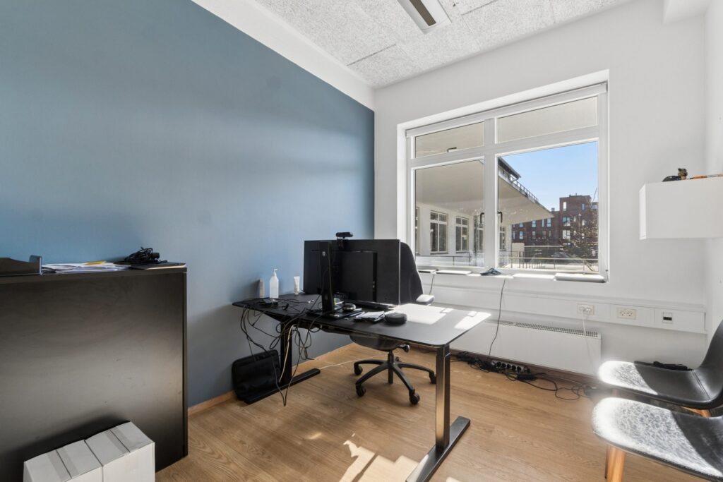 Moderne kontormiljø i Kirkebjerg Vigespor med lyse arbejdsrum og bevarede industrielle detaljer.
