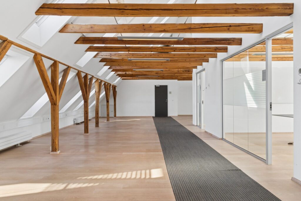 Moderne kontormiljø i Kirkebjerg Vigespor med lyse arbejdsrum og bevarede industrielle detaljer.