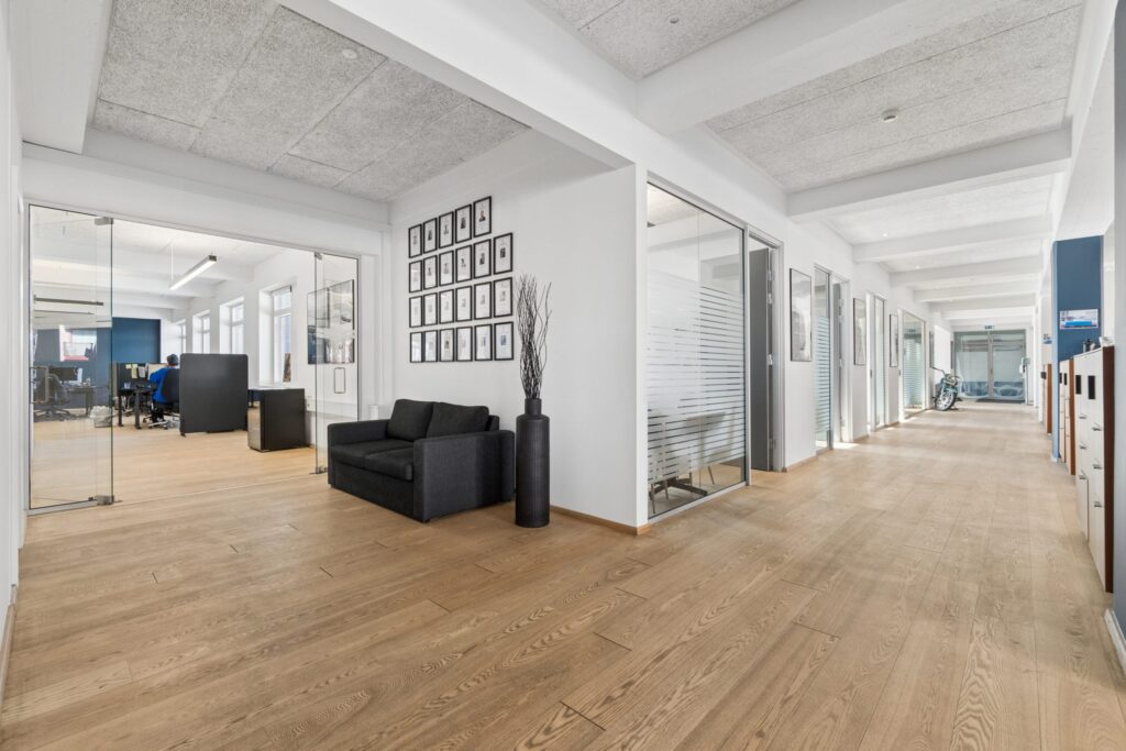 Moderne kontormiljø i Kirkebjerg Vigespor med lyse arbejdsrum og bevarede industrielle detaljer.