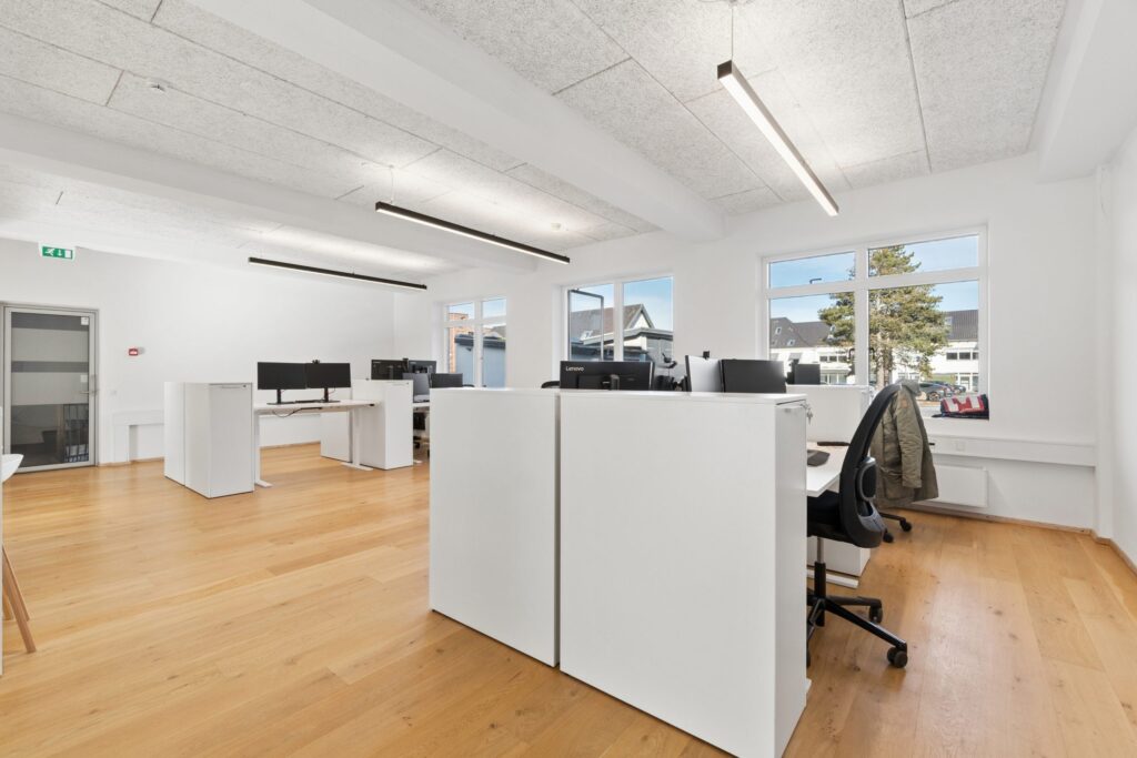 Moderne kontormiljø i Kirkebjerg Vigespor med lyse arbejdsrum og bevarede industrielle detaljer.