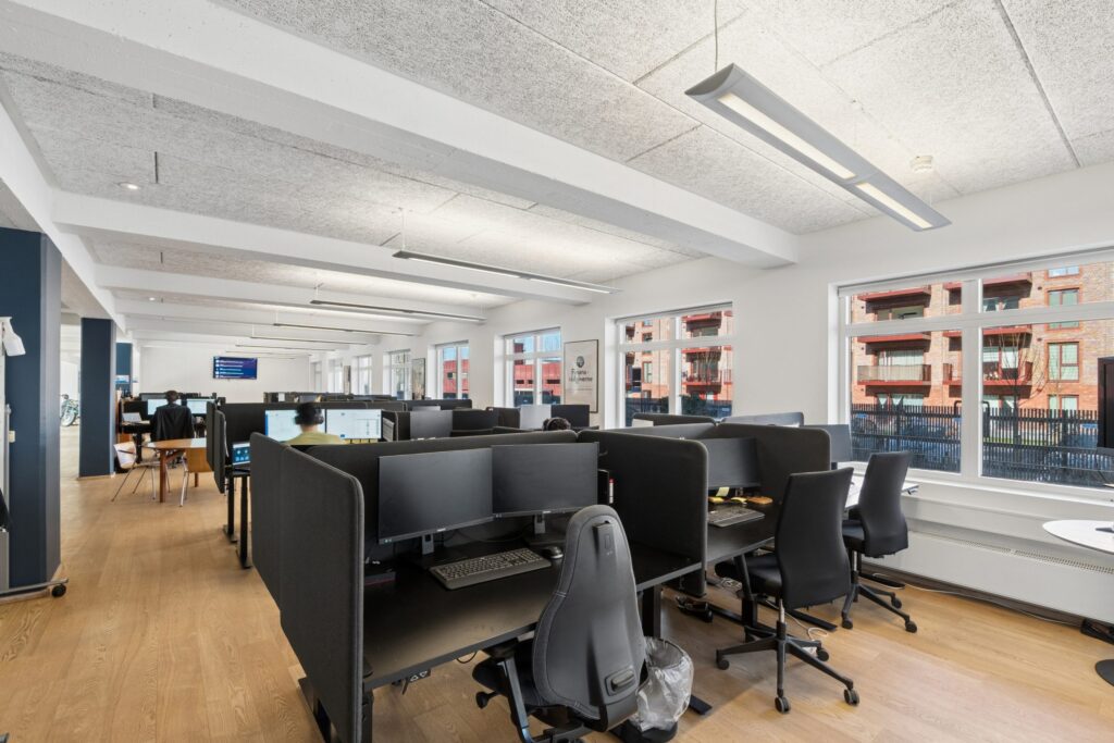 Moderne kontormiljø i Kirkebjerg Vigespor med lyse arbejdsrum og bevarede industrielle detaljer.