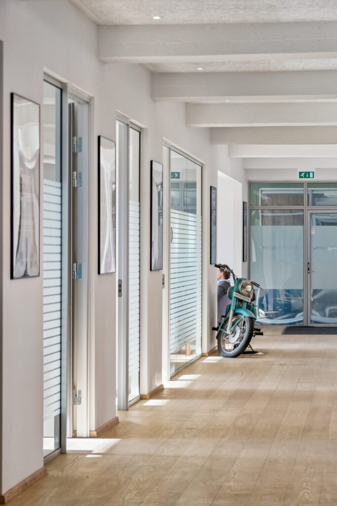 Moderne kontormiljø i Kirkebjerg Vigespor med lyse arbejdsrum og bevarede industrielle detaljer.