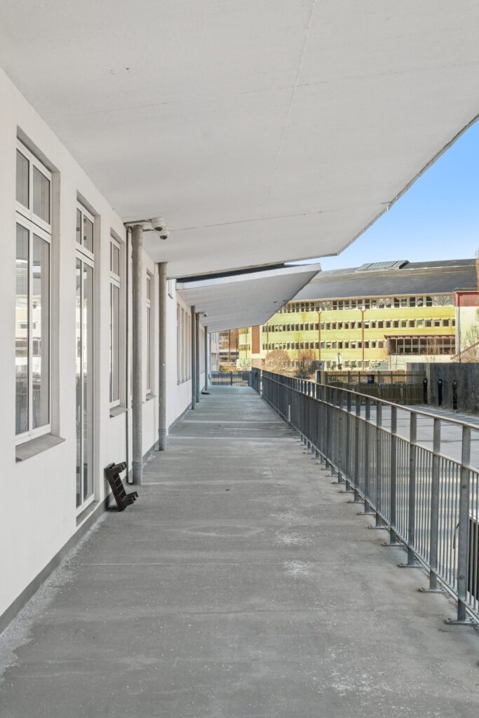 Moderne kontormiljø i Kirkebjerg Vigespor med lyse arbejdsrum og bevarede industrielle detaljer.
