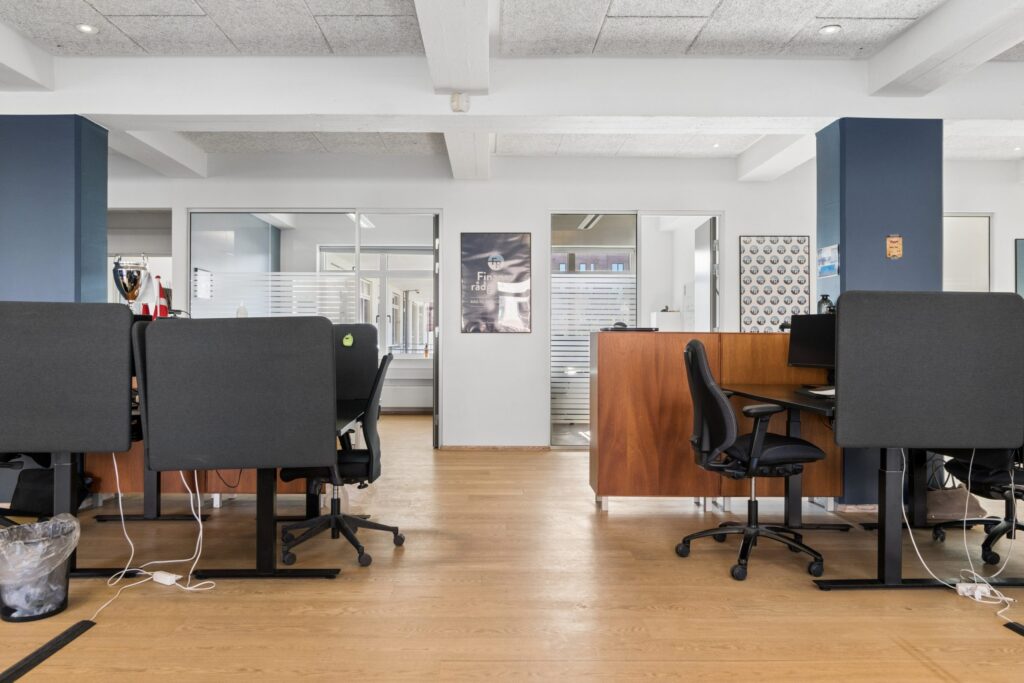 Moderne kontormiljø i Kirkebjerg Vigespor med lyse arbejdsrum og bevarede industrielle detaljer.