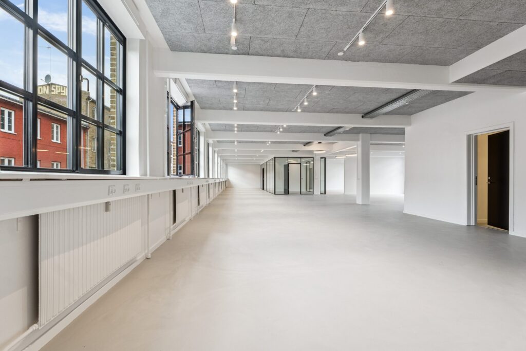 Lyse erhvervslokaler på Bygmestervej 3-5 med store vinduespartier og fleksible arbejdsområder.