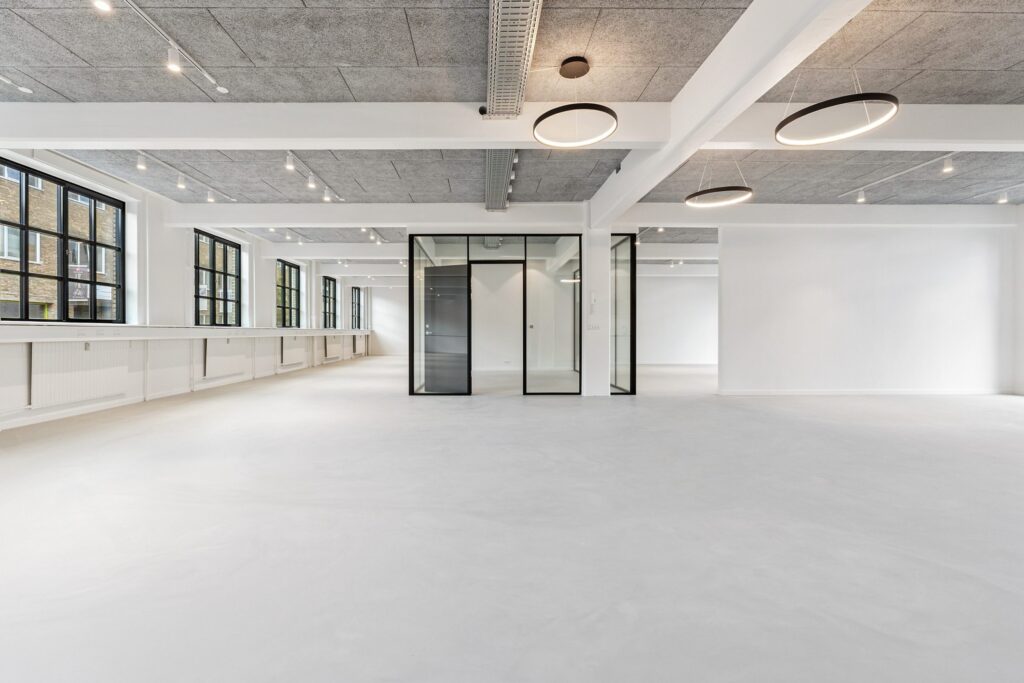 Lyse erhvervslokaler på Bygmestervej 3-5 med store vinduespartier og fleksible arbejdsområder.
