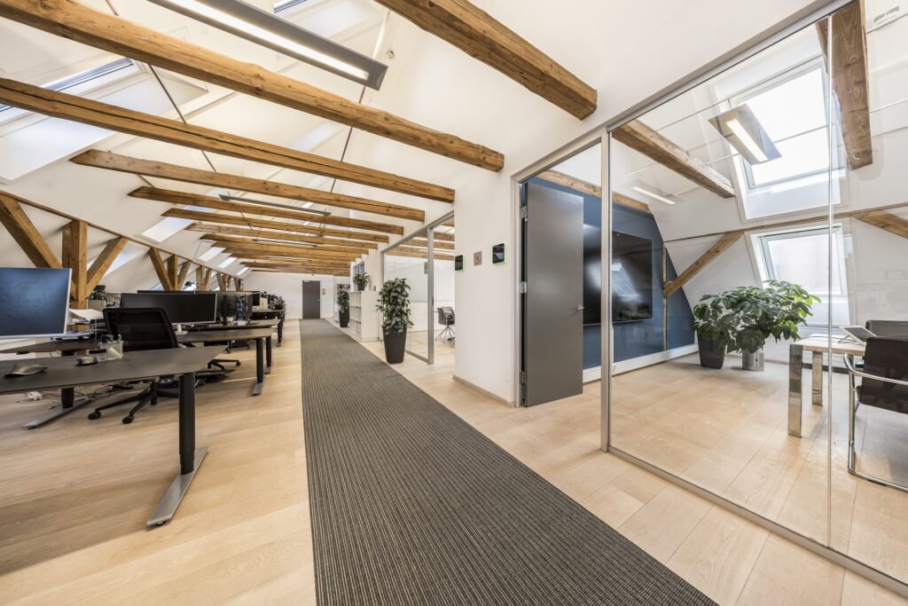 Moderne kontormiljø i Kirkebjerg Vigespor med lyse arbejdsrum og bevarede industrielle detaljer.